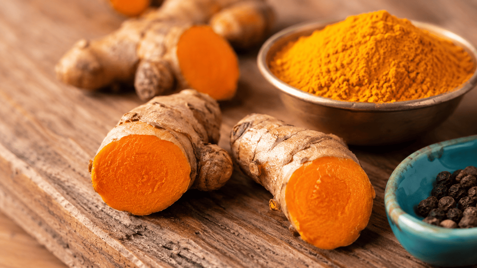 Fresh turmeric root and turmeric powder showing natural curcumin content